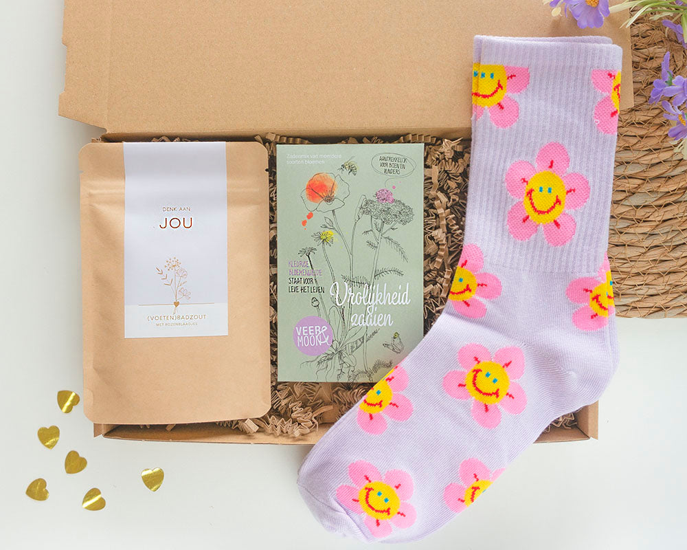 brievenbuscadeau om te laten weten dat je aan iemand denkt met daarin sokken, bloemzaden met vrolijkheid zaaien en een zakje badzout met denk aan jou