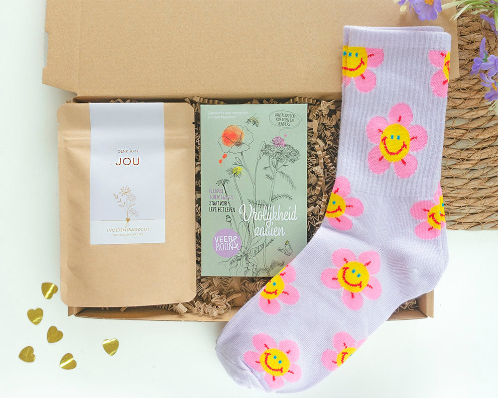 brievenbuscadeau om te laten weten dat je aan iemand denkt met daarin sokken, bloemzaden met vrolijkheid zaaien en een zakje badzout met denk aan jou