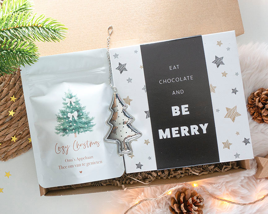 Warm kerst brievenbuscadeautje met thee, chocolade en feestelijke details, ideaal als kerstcadeau voor haar