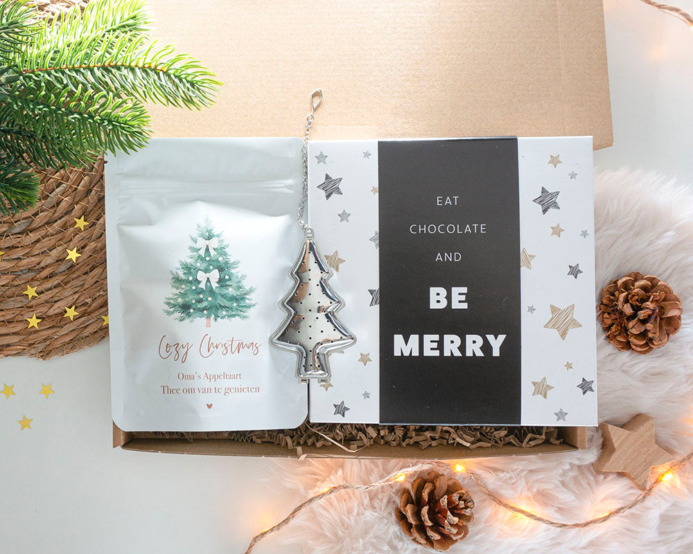 Kerstcadeau voor een vrouw met kerstthee, chocolade en kerstboom-thee-ei, liefdevol verpakt als brievenbuscadeau
