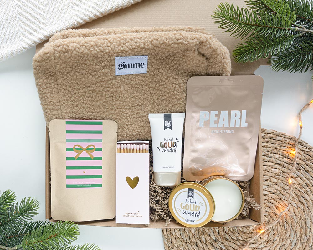 Knusse Kerst brievenbuscadeau voor vrouwen met selfcare producten zoals teddy-toilettas, handcrème, geurkaars en gezichtsmasker voor ontspanning en warme winterverwennerij