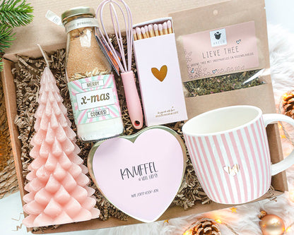 Luxe kerstcadeaupakket voor haar – Zoet Kerstgeluk met mok met goud hartje, kerstkoekjesmix, thee en kaars in warme roze tinten.