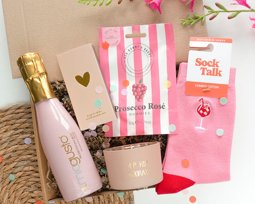 Feestelijk cadeaupakket met Il Mio Gusto prosecco, beige lucifers met gouden hartje en roze Cheers sokken
