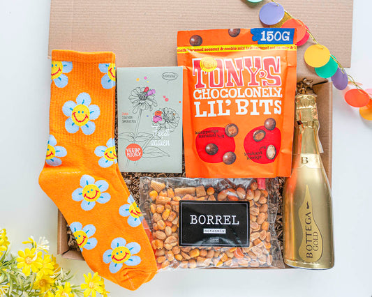 feestelijk verjaardagscadeau voor haar met daarin leuke cadeautjes zoals sokken, bloemzaden, chocolade, borrelnootjes en een flesje prosecco of een mocktail.