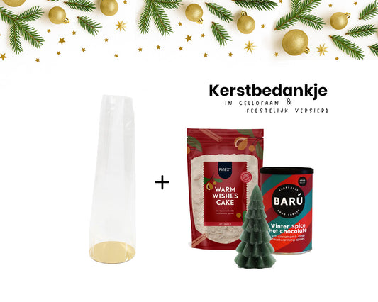 Kerstbedankje in cellofaan met bakmix ‘Warm Wishes Cake’, blikje warme chocolademelk en kerstboomkaarsje – feestelijk verpakt met lint en sticker.
