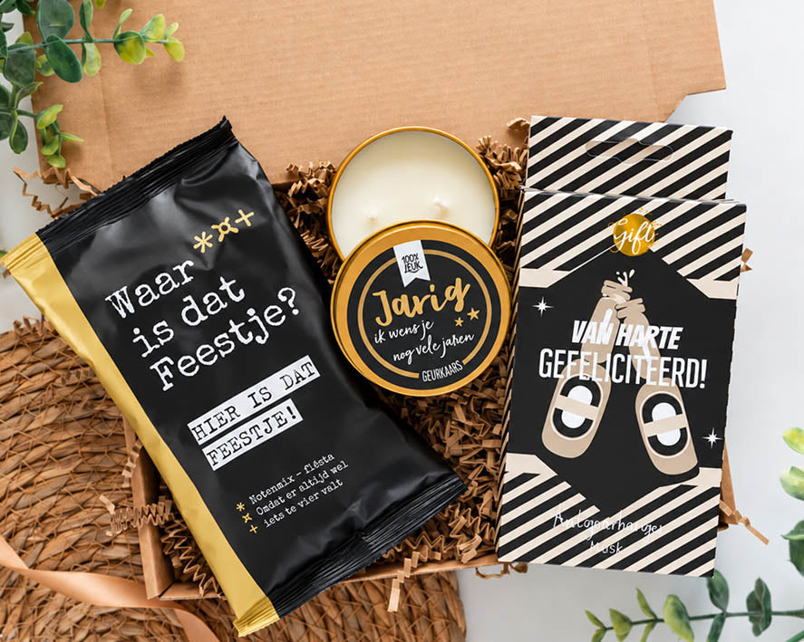 Stoer verjaardagscadeau voor hem met feestelijke notenmix, geurkaars Jarig en autogeurhanger met bierflesjes.