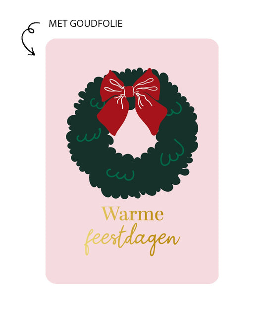 Roze kerstkaart met groene kerstkrans, rode strik en goudfolie tekst Warme feestdagen
