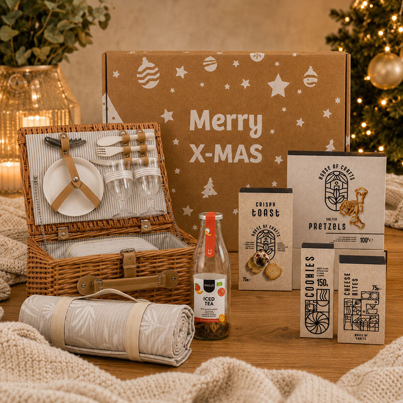 Sfeerfoto kerstpakket Buiten & Bites met picknickmand, kleed en lekkernijen
